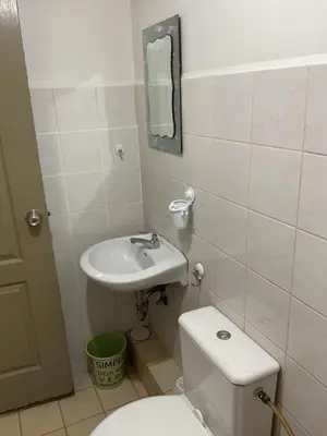 a small bathroom with a toilet and a sink at DBK HOMES Sorrento Oasis in Manila