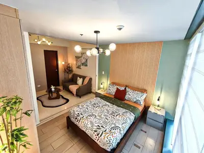 a bedroom with a bed and a living room at Condo in BGC - Uptown Mall in Manila