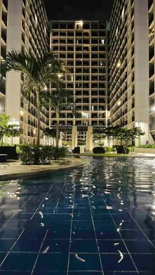 a large building with palm trees in front of it at Pikamon - 15 mins to Airport - Arcade - Shore 2 - MOA in Manila