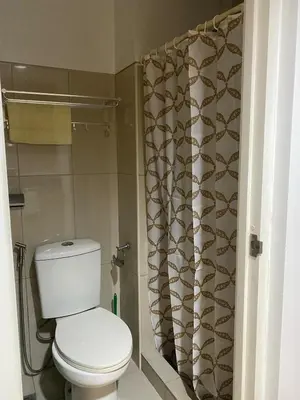 a bathroom with a toilet and a shower curtain at Shell residences Tower D in Manila