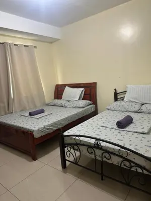 two beds sitting next to each other in a room at Shell Residences -weng's-place in Manila