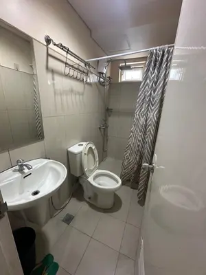 a bathroom with a toilet and a sink at Shell Residences -weng's-place in Manila