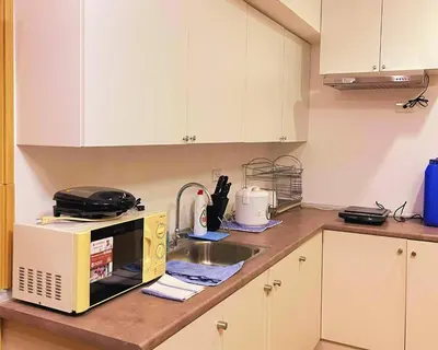 a kitchen counter with a microwave and a sink at Charm's City Escape at Grace Residences in Manila