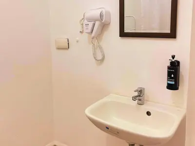 a bathroom with a sink and a phone on the wall at Charm's City Escape at Grace Residences in Manila