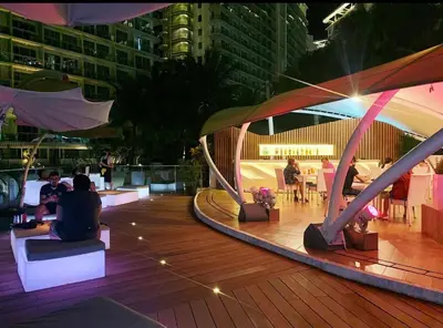 a group of people sitting on a deck at night at Azure Urban Resort Residences Parañaque City in Manila
