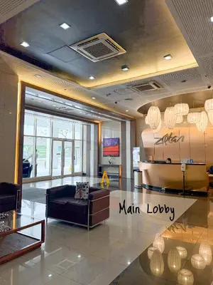 a lobby with a main lobby with a couch and a table at Roomies Spacious Fully Furnished Condo with Balcony and Netflix for 4pax in Manila