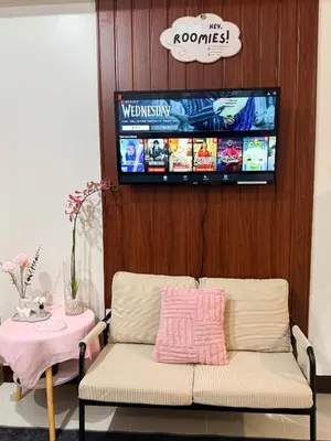a living room with a couch and a flat screen tv at Roomies Spacious Fully Furnished Condo with Balcony and Netflix for 4pax in Manila