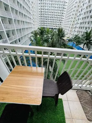 a table and chairs on a balcony with buildings at Shore Residence 2br 5f walking distance MOA near airport in Manila
