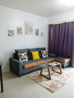 a living room with a couch and a table at Shore Residence 2br 5f walking distance MOA near airport in Manila