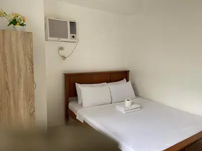 a small bedroom with a bed with a candle on it at SHORE Residence d42 walking distance MOA near Airport in Manila