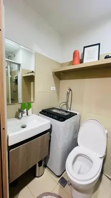 a small bathroom with a toilet and a sink at Luna Suite in Manila
