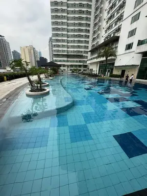 a large blue tile swimming pool in a city at The Beacon Makati in Manila