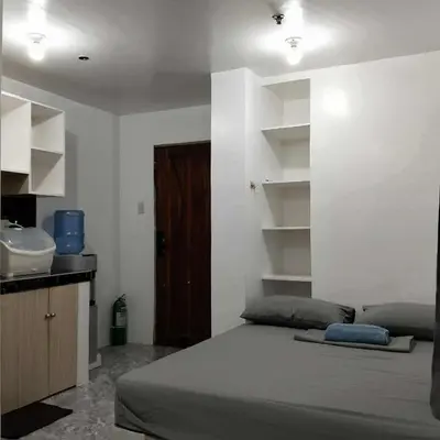 a bedroom with a bed and a sink in it at W Tramo Residences in Manila