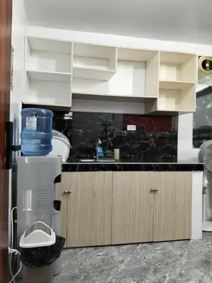 a kitchen with white cabinets and a black counter top at W Tramo Residences in Manila