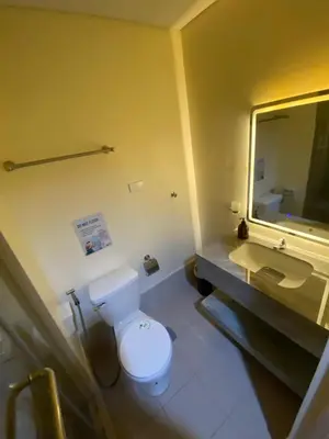 a bathroom with a white toilet and a sink at Hallin Bay Suites Modern 1BR with balcony in Manila