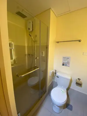 a bathroom with a toilet and a glass shower at Hallin Bay Suites Modern 1BR with balcony in Manila
