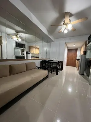 a living room and kitchen with a couch and a table at Sea Residences SM Mall of Asia Cj in Manila