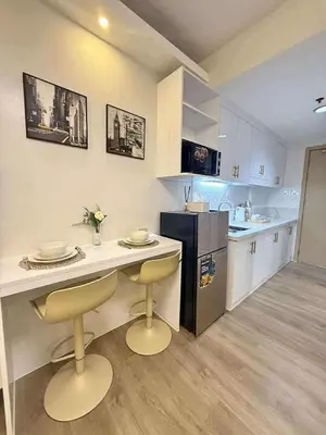 a kitchen with a table and two chairs and a counter at Sea Residences SM Mall of Asia Cj in Manila
