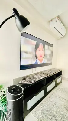 a television screen with a woman on it in a living room at 2 bedroom Luxury Condo in Eastwood with Scenic City view, unli wifi and netflix in Manila