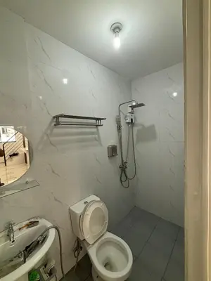 a white bathroom with a toilet and a sink at A peace and quiet home away from your home in Calamba