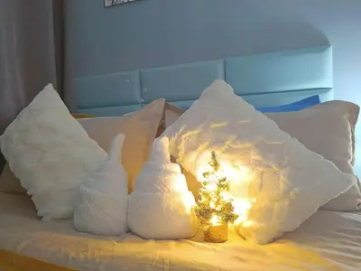 two white pillows with a christmas tree on a bed at SkyShore Suites in Manila