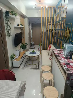 a restaurant with a table and stools in a room at SkyShore Suites in Manila