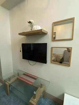 a living room with a tv and a glass table at Staycation Delight by R2CK in Manila