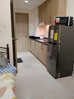a kitchen with a stainless steel refrigerator in a room at Jaina Staycation in Manila