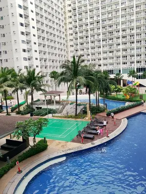 an aerial view of a pool with a tennis court at Jaina Staycation in Manila