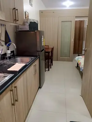 a kitchen with a sink and a refrigerator at Jaina Staycation in Manila