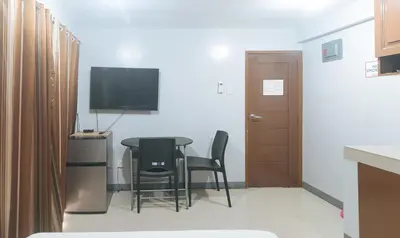 a small room with a table and chairs and a television at VCloud Hills Boarding House Near NAIA Terminal in Manila