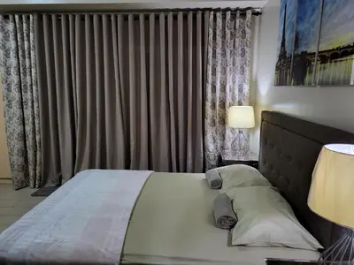 a bedroom with a bed and a window with curtains at Liana's Condo Newport City in Manila
