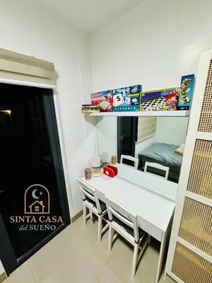 a dining room with a white table and chairs at Sinta Casa del Sueno MOA Stay with Pool and Wi-fi in Manila