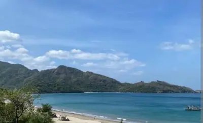a view of a beach with mountains in the background at Auntie's in Tanza