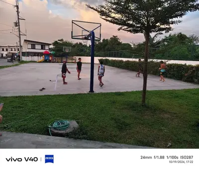 a group of people playing basketball in a park at Auntie's in Tanza