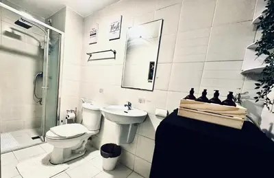 a white bathroom with a toilet and a sink at High Rise 2br In the Makati Skyline with KTV Pools in Manila
