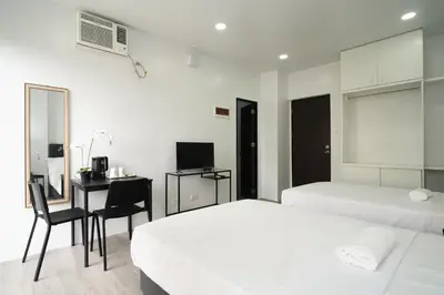 a bedroom with two beds and a desk with a computer at 20 Boeing Apt in Manila