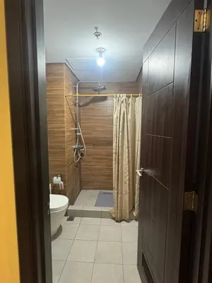 a bathroom with a toilet and a shower with a shower curtain at Levi & Moon Relax and Chill in Manila