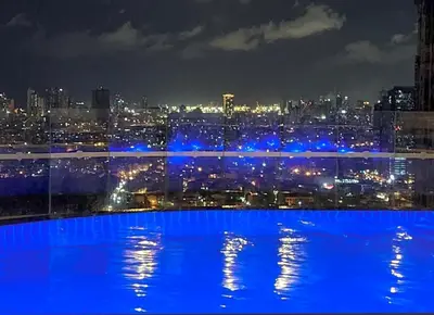 a view of a city at night with blue lights at Condo Living - Pool, Balcony, Gym, Fast WiFi in Manila