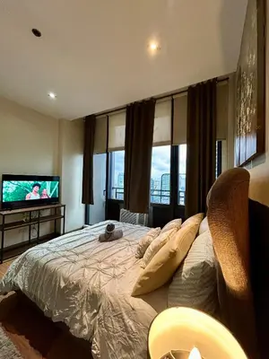 a bedroom with a large bed and a flat screen tv at Condo Living - Pool, Balcony, Gym, Fast WiFi in Manila