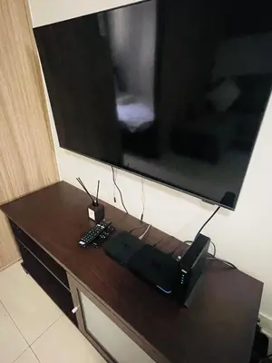 a television on top of a wooden table at Shore Residences Moa Pasay in Manila
