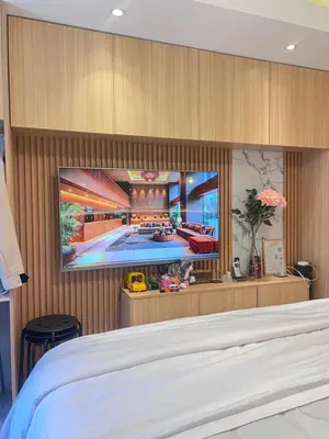 a bedroom with a tv on a wall at Condo Living at Shore with Parking in Manila