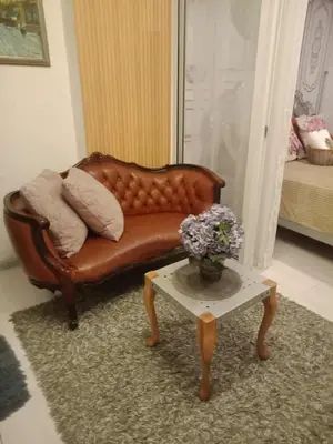 a brown leather couch in a living room with a table at Azure Urban Resort Residences - St Tropez Tower in Manila