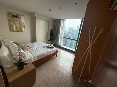 a bedroom with a bed and a large window at One Uptown Residence, BGC - Standard 2 Bedroom Unit in Manila