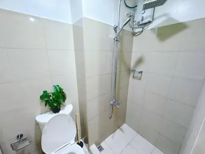 a bathroom with a shower with a toilet and a plant at SHORE 2 TOWER 2 7th floor Near MOA Easy Vacation Shopping Center in Manila