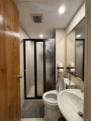 a bathroom with a toilet and a sink at Horiyama staycation azure in Manila