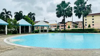 a large swimming pool with palm trees and buildings at Terravive in Manila