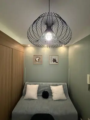 a bedroom with a bed with a large chandelier at The Nook in Pasay in Manila