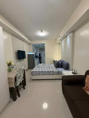 a bedroom with a bed and a couch in a room at Sea Residences Condotel With Balcony, by Rose in Manila