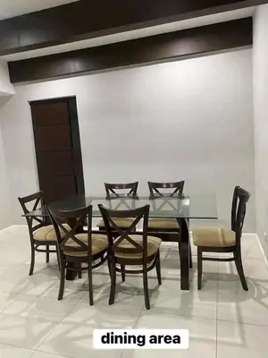 a dining room with a glass table and chairs at Sunvalley B&b in Manila